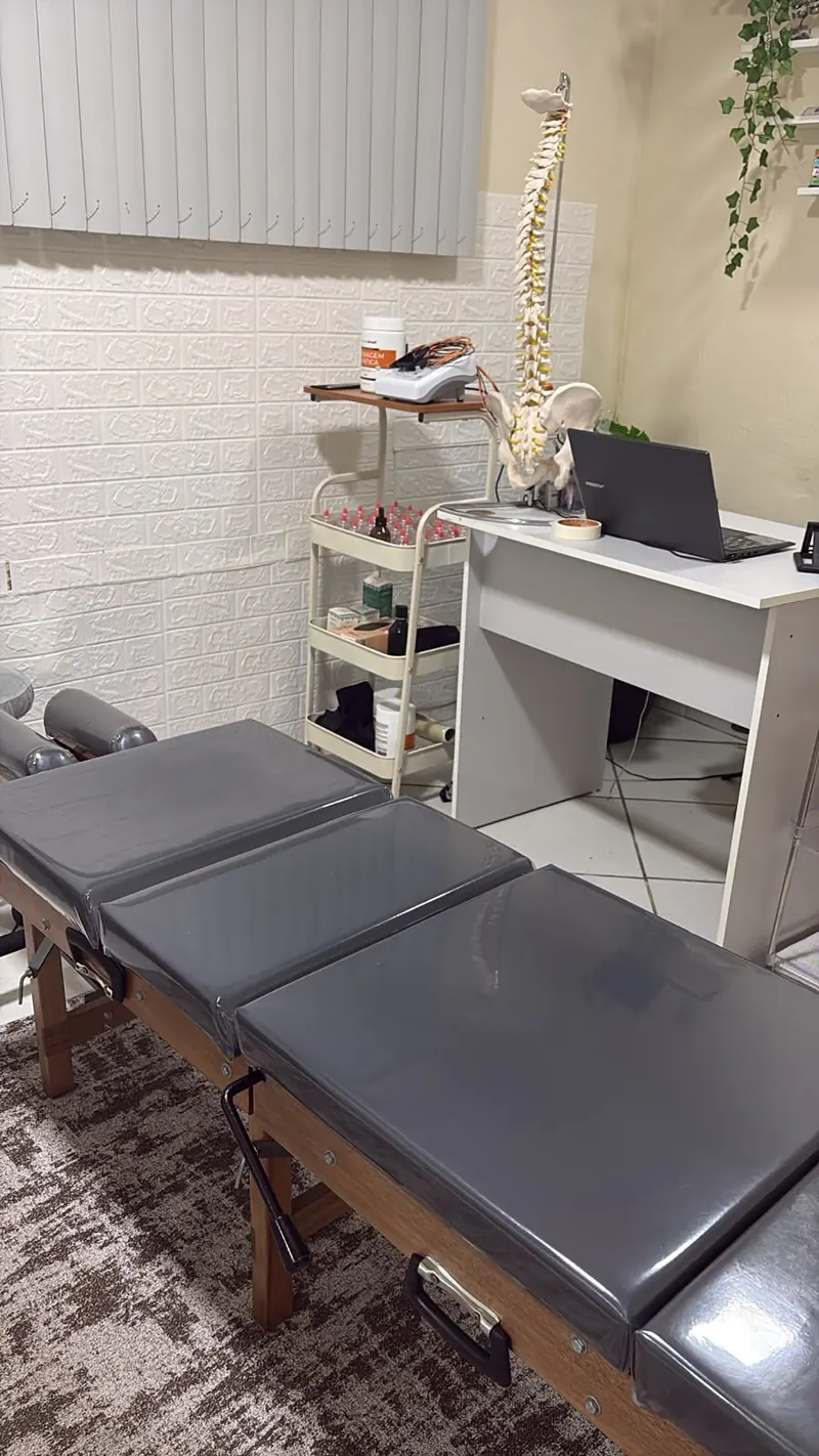 Sala de atendimento de quiropraxia da Coluna Equilibrium em Joinville, com maca quiroprática e modelo da coluna vertebral